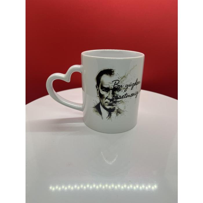 Atatürk Tasarımlı Kalpli Kupa – “Bu Yüzden Öğretmeniz” Yazılı, Mavi Gözlü Kara Kalem Çizim