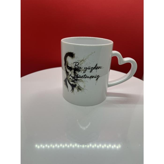 Atatürk Tasarımlı Kalpli Kupa – “Bu Yüzden Öğretmeniz” Yazılı, Mavi Gözlü Kara Kalem Çizim